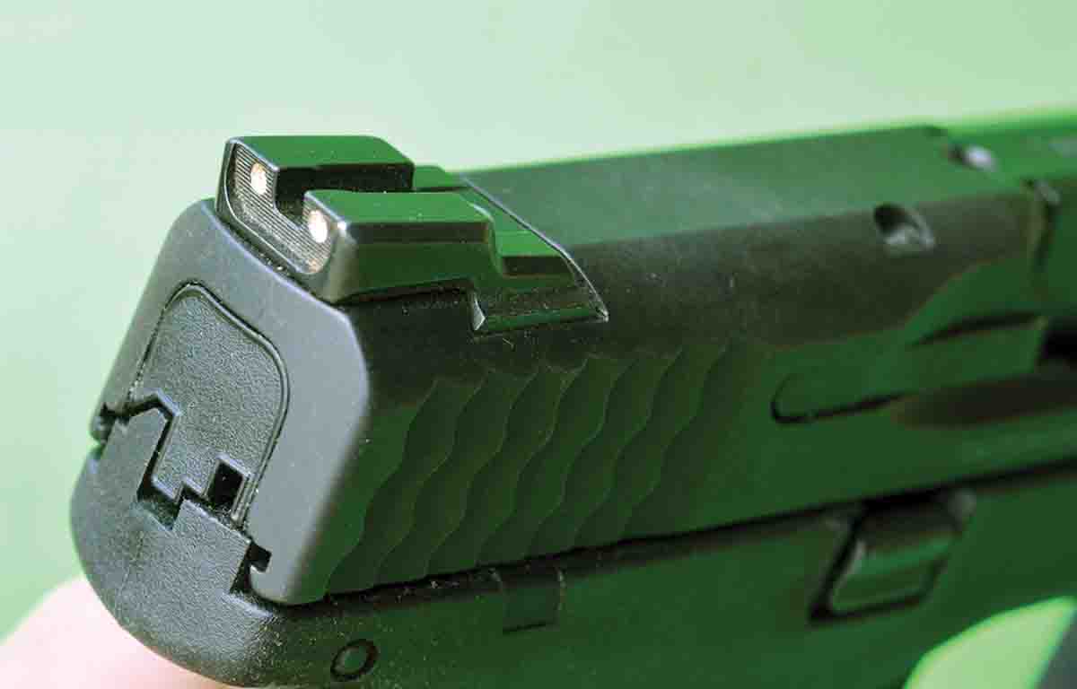 The Novak rear sight features drift windage adjustment and two white dots.
